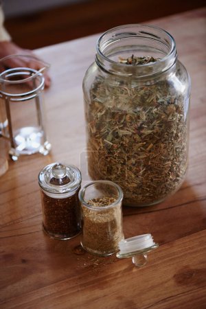 Photo for Jar, tea leaves and herbal plant on kitchen counter or health benefits or morning beverage, refreshing or wellness. Bottle, vitality and prepare as hot drinking or jasmine, hibiscus or stress relief. - Royalty Free Image