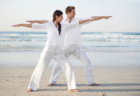 Téléchargez les photos : Couple, yoga et bras ouverts, fitness sur la plage pour zen et bien-être, voyage et pleine conscience avec guérison holistique. Personnes en plein air, l'exercice et l'équilibre, l'entraînement ensemble pour coller avec la mer et la nature. - en image libre de droit