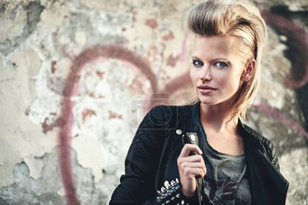 Photo for Woman, portrait or cosmetics in edgy fashion with punk rock hairstyle, attitude or cool in funky clothes by graffiti wall. Artist, face and leather jacket in urban town and trendy style by street art. - Royalty Free Image