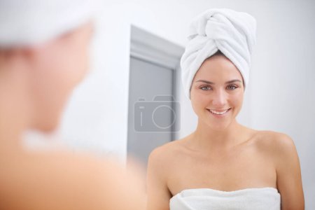 Téléchargez les photos : Les femmes, sourire et miroir pour les soins de la peau, beauté et salle de bains se préparent pour le spa et le massage. Femme, serviette et auto-soin pour la réflexion, le traitement et le bien-être pour une bonne propreté faciale. - en image libre de droit
