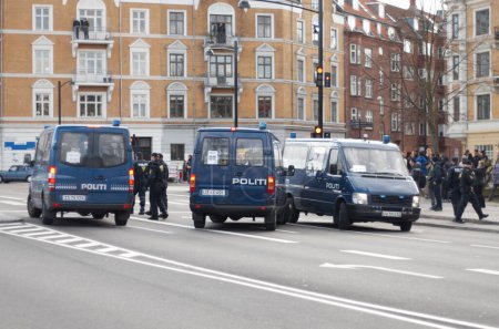 Photo for Police, van and street with crowd, safety or protection service for public with justice in city. Vehicle, law enforcement and outdoor for danger, arrest and transportation on urban road in Copenhagen. - Royalty Free Image