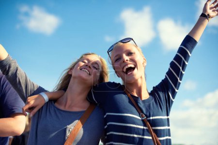 Téléchargez les photos : Femmes, souriez et levez les bras contre le ciel bleu avec liberté, joie et liens pendant les vacances de printemps aux États-Unis. Étudiantes, meilleures amies ou filles avec les mains, soleil et maquettes le week-end en été. - en image libre de droit