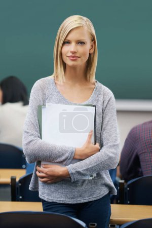 Photo for Student, classroom and portrait of woman in college for study, learning and development at campus. Female person, confident and paper for education, knowledge or academic growth at university. - Royalty Free Image