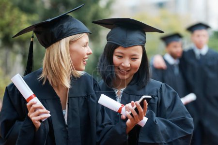 Photo for Phone, graduation and students in college or university to celebrate school diploma or degree. Mobile app, happy graduate friends or women with education certificate for goal notification or news. - Royalty Free Image