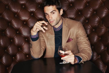 Photo for Portrait, cigar and businessman drinking at club, fashion and person in a suit with alcohol at vintage bar. Face, smoking and serious person with whiskey, scotch and brandy in glass for luxury at pub. - Royalty Free Image