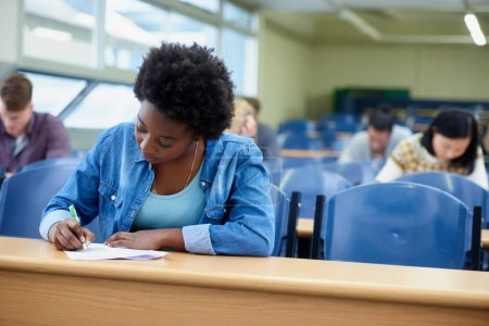 Photo for Writing, college and black woman student in classroom studying for test, exam or assignment. Education, university and African female person working on project with knowledge in lecture hall - Royalty Free Image