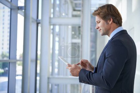 Photo for Tablet, office and business man by window for social networking, typing email and connection. Corporate worker, professional and person on digital technology for online search, website and internet. - Royalty Free Image