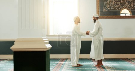 Téléchargez les photos : Musulman, poignée de main et les gens de la mosquée pour l'accueil, la conversation et le respect dans la communauté islamique. Culte, amis et hommes serrant la main dans le bâtiment religieux pour le Ramadan Kareem, prière et soutien. - en image libre de droit