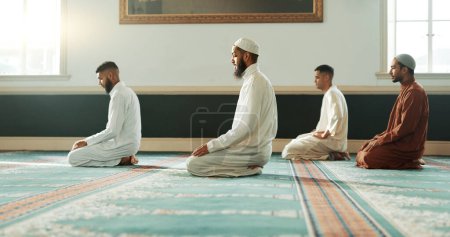 Téléchargez les photos : Islamiques, priant et saints hommes dans une mosquée pour la religion spirituelle ensemble comme un groupe pour adorer Allah dans le Ramadan. Musulmans, Arabes et personnes en paix ou dans le respect de la gratitude, de la confiance et de l'espoir. - en image libre de droit