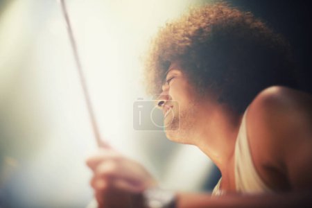 Photo for Man, drummer and musician in performance at stage for rock concert, music festival and energy. Person, artist and play wiht drumstick for entertainment, sound and rehearsal on percussion instrument. - Royalty Free Image