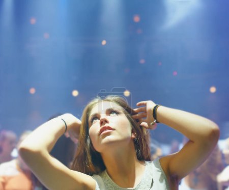 Photo for Club, night and woman at party to dance to techno or dj at music festival and rave at concert event. Nightclub, girl and celebration with energy, light and relax with movement to disco on vacation. - Royalty Free Image