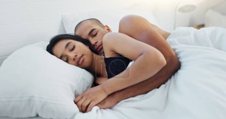 Photo for Couple, hugging and sleeping in bed together, love and resting or comfortable at home on weekend. People, bedroom and security in embrace, bonding and nap on sunday morning and relaxing or dreaming. - Royalty Free Image
