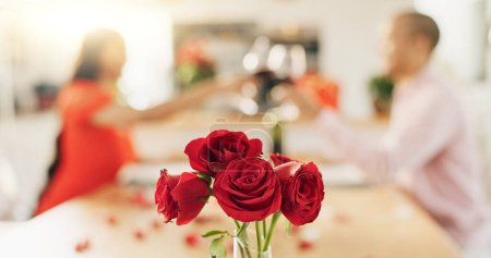 Téléchargez les photos : Couple, roses et pain grillé à la maison avec verre à vin pour célébrer l'amour, la romance et la Saint-Valentin. Les gens acclament pour le succès de la date, boire du champagne rouge et dîner de luxe à une table avec des fleurs. - en image libre de droit