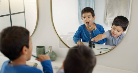 Téléchargez les photos : Garçons, brosse à dents et ensemble dans la salle de bain pour l'hygiène, le bien-être et l'autosoin avec des produits dentaires dans la maison familiale. Jeunes enfants mâles, blanchiment des dents et miroir pour la santé, l'apprentissage et le nettoyage. - en image libre de droit
