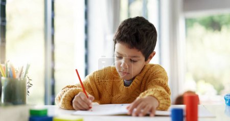 Photo for Student, drawing or boy writing homework on notebook in kindergarten education for growth development. Project, creative or young kid artist with color pencil learning or working on sketching skills. - Royalty Free Image