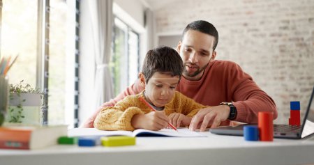 Photo for Father, boy child and homework with laptop, writing and helping hand for education, childhood development or care. Man, dad and male kid with home school, notebook and computer with teaching at desk. - Royalty Free Image