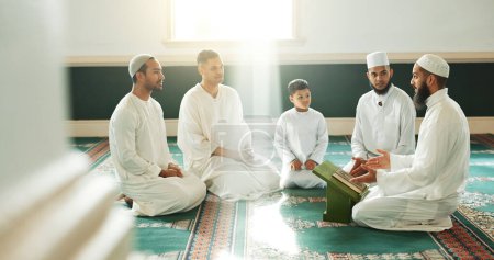 Téléchargez les photos : Musulman, religion et personnes dans la mosquée pour la prière, l'éducation religieuse et le culte ou la prière. Communauté islamique, connaissances et hommes parlant sur le tapis pour Ramadan Kareem, apprenant le Coran et l'Aïd Moubarak. - en image libre de droit