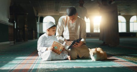 Koran, Kind und Mann, die in einer Moschee für Gebet, Frieden und spirituelle Fürsorge in heiliger Religion für Allah lehren. Buch lesen, lernen oder muslimische Person mit Tablet, Kind oder Bildung zur Gottesverehrung.