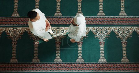 Foto de Musulmanes, religión y vista superior de las personas en la mezquita para hablar, conversar y saludar en comunidad. El culto islámico, amigos y superiores de los hombres en el edificio religioso para el Ramadán, la oración y la alabanza. - Imagen libre de derechos
