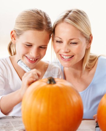 Photo for Child, mother and smile for drawing on pumpkin, craft and celebrate halloween party at home. Happy girl kid, mom or family writing with pen marker on vegetable, holiday lantern or creative decoration. - Royalty Free Image