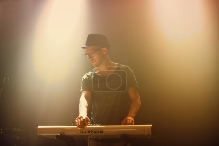 Photo for Music, concert and man playing keyboard for performance at night with glasses in entertainment. Musician, artist and instrument for party and culture song at nightclub on new years eve at festival. - Royalty Free Image