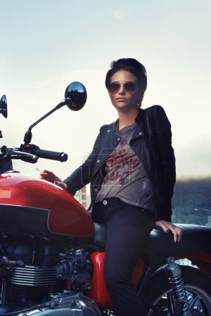 Photo for Motorcycle, leather and rebel woman in city with sunglasses for travel, transport or road trip. Fashion, evening and person with attitude on classic or vintage bike for transportation or journey. - Royalty Free Image