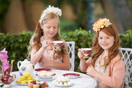Photo for Tea, party and girl children are playing with fine china, celebration and fun in backyard. Relax, spring with cake or dessert, beverage or drink with friends outdoor in garden for game or birthday. - Royalty Free Image