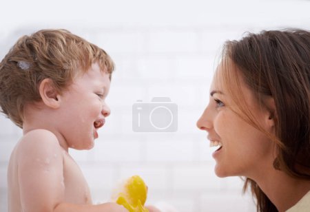 Photo for Happy, rubber duck and mother bathing baby for hygiene, body care and health at family home. Smile, toy and young mom washing and bonding with infant, kid or child toddler in bathroom of house - Royalty Free Image
