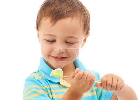 Téléchargez les photos : Garçon enfant, dentifrice et brosse à dents en studio avec sourire pour la santé, le nettoyage et l'hygiène par fond blanc. Enfant, pensant et heureux de choisir, d'apprendre et de se brosser les dents pour le bien-être dentaire. - en image libre de droit