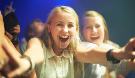 Photo for Friends, happy or selfie at concert in portrait, bonding or excited for social fun at music festival. Women, together or smile on face at live show, event or celebration in crowd at disco performance. - Royalty Free Image
