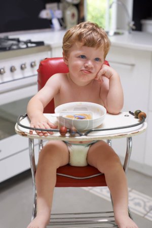 Photo for Eating, toddler and boy in chair for food, feeding or meal in house kitchen or home for breakfast. Hungry kid, baby thinking and healthy child with bowl for nutrition, natural diet or growth alone. - Royalty Free Image