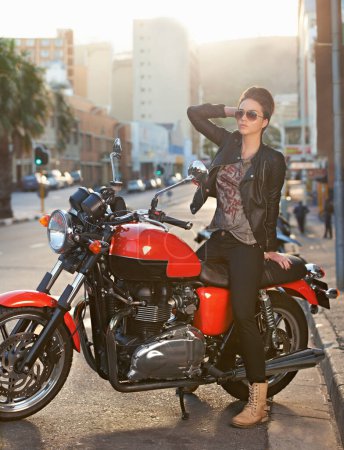 Photo for Bike, fashion and woman in city with sunglasses for travel, transport or road trip as rebel. Leather, asphalt and model with attitude on classic or vintage motorcycle for transportation or journey. - Royalty Free Image