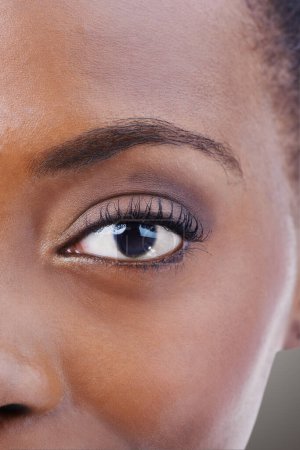 Photo for Eyeshadow, makeup and black woman closeup with beauty and skincare on half of face. Eye, portrait and African model with healthy glow and shine on skin from dermatology, cosmetics or foundation. - Royalty Free Image