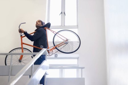 Photo for Bicycle, stairs and man carrying bike for exercise and eco friendly transportation with travel. Staircase, carbon neutral and cyclist with apartment complex and journey of walking steps in building. - Royalty Free Image