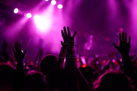 Téléchargez les photos : Mains, foule et silhouette au festival de musique avec danse pour fête rock au concert avec lumières de scène, discothèque ou DJ. Personnes, piste de danse et événement de vacances en été pour le divertissement, sombre ou amusant. - en image libre de droit