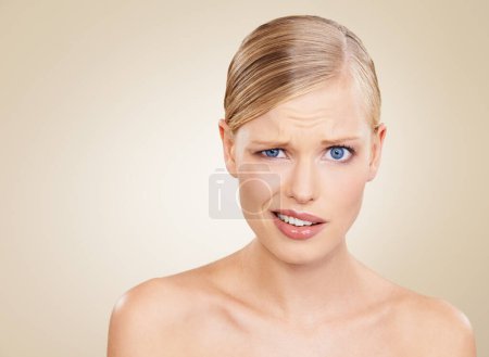 Photo for Portrait, doubt and space for beauty with woman in studio on beige background to question wellness. Confused, skincare and funny face for problem on mockup with young model at spa for dermatology. - Royalty Free Image