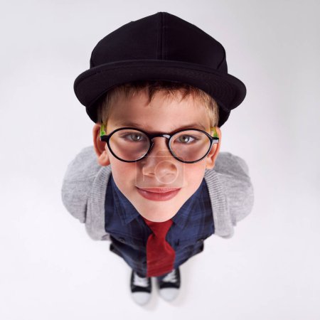 Foto de Gafas, felices y retrato de niño en estudio para el cuidado de los ojos, la visión y la salud óptica. Sonrisa, optometría y vista superior del niño con gafas elegantes o gafas aisladas por el fondo gris - Imagen libre de derechos