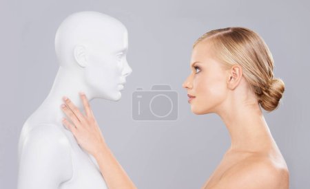 Photo for Studio, woman and mannequin with perfect beauty versus fake standard, identity and facial wellness. Girl, doll and face in profile for cosmetics, plastic surgery or makeup on grey background - Royalty Free Image