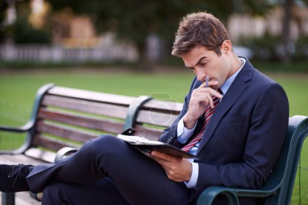 Thinking, business man and notebook at park bench for opportunity, dream or vision for remote work. Journal, idea or consultant outdoor with decision, inspiration and serious employee planning future.