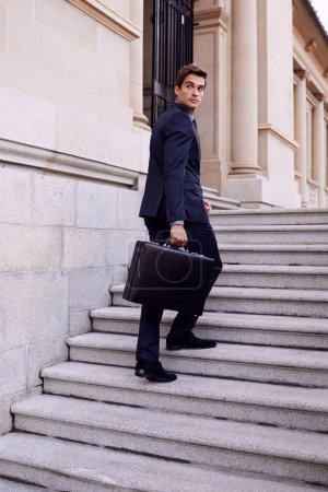Photo for Business, briefcase and man walking on stairs outside law firm in city with evening commute, sidewalk and court building. Businessman, lawyer or attorney on outdoor steps with bag for urban travel - Royalty Free Image