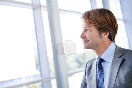 Photo for Thinking, smile and businessman by window in office for planning, problem solving or brainstorming. Happy, ideas and professional male lawyer or attorney with vision for legal case in workplace - Royalty Free Image