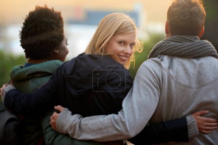 Photo for College, friends and portrait with hug outdoor for bonding, relax and break on campus with diversity. University, people and smile with embrace for support, education and learning fun with rear view. - Royalty Free Image