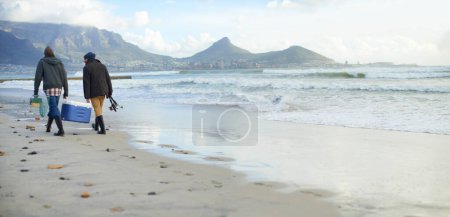 Foto de Pescadores, equipo o caminar en la playa para pescar en la mañana nublada o por la tarde en Ciudad del Cabo. Amigos, hombres o turistas masculinos con red, poste y caja más fría por mar, orilla o costa para maqueta. - Imagen libre de derechos