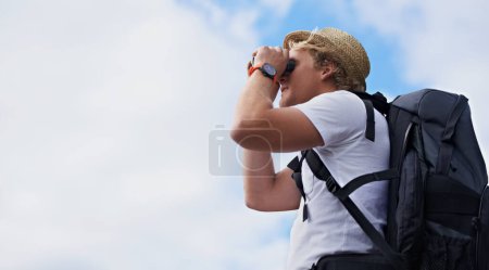 Photo for Man, hiker and binoculars with backpack for hiking, sightseeing or outdoor travel with blue sky background. Male person, traveler or tourist with bag or optical instrument for view, vision or scope. - Royalty Free Image