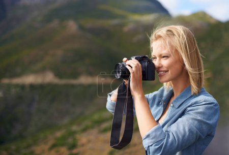 Téléchargez les photos : Femme heureuse, blonde et appareil photo pour la photographie de plein air, photo ou visite touristique sur la montagne. Jeune femme ou journaliste avec le sourire pour la photo, la vue ou la mémoire dans l'environnement naturel dans la nature. - en image libre de droit