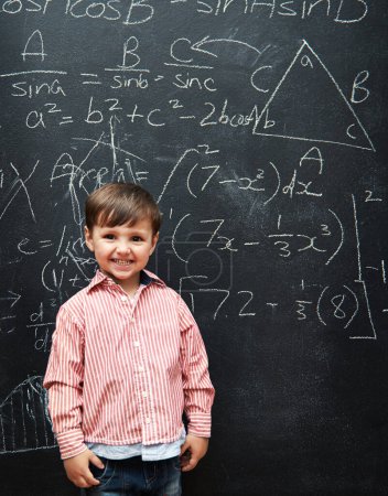Photo for Smart, kid and math on chalkboard for school, learning and education with happy portrait and confidence. Genius and clever child, boy or student with equation, numbers and test for IQ or intelligence. - Royalty Free Image