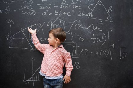 Photo for Child, boy and blackboard with math or equations for knowledge, numbers and hand gesture in classroom at school. Kid, student and learning by chalkboard for problem solving, studying and preschool. - Royalty Free Image