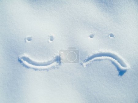 Foto de Emoji, cara y dibujo en la nieve o al aire libre en el suelo en invierno para la comunicación o retroalimentación. Escribir, firmar y sonreír en el hielo en el campo en la naturaleza con el fondo congelado y la reseña del boceto escrito. - Imagen libre de derechos