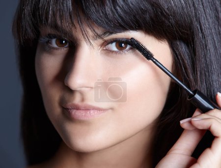 Photo for Beauty, skincare and portrait of woman with mascara for natural makeup, facial and studio. Lashes, application and cosmetics with face of girl isolated on blue background with brush, tools and pride - Royalty Free Image
