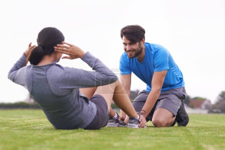Photo for Personal trainer, man and woman with sit ups on grass for fitness, training and helping hand in summer. People, support and motivation for abdomen exercise with workout on park lawn in Australia. - Royalty Free Image
